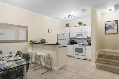 a kitchen with white appliances and a table and chairs at Disney Getaway Private Pool Themed Bedrooms. Book Now LV8 in Kissimmee