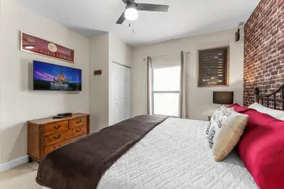 a bedroom with a large bed and a brick wall at Disney Getaway Private Pool Themed Bedrooms. Book Now LV8 in Kissimmee