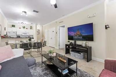 a living room with a couch and a tv on a wall at Disney Getaway Private Pool Themed Bedrooms. Book Now LV8 in Kissimmee