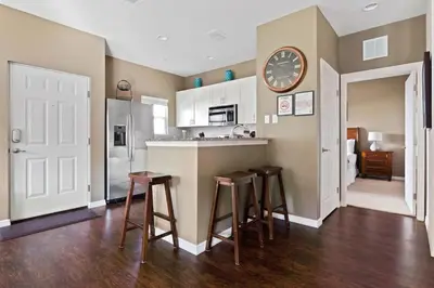 a kitchen with a bar with stools and a clock on the wall at Disney Getaway Private Pool Themed Bedrooms. Book Now LV7 in Kissimmee