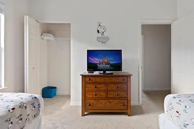 a bedroom with a tv on a wooden dresser at Disney Getaway Private Pool Themed Bedrooms. Book Now LV7 in Kissimmee