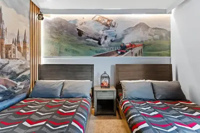 a bedroom with two beds and a painting on the wall at Disney Getaway Private Pool Themed Bedrooms. Book Now WLV83 in Kissimmee