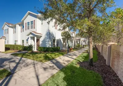 a white house with a tree and a sidewalk at Disney Getaway Private Pool Themed Bedrooms. Book Now WLV19 in Kissimmee