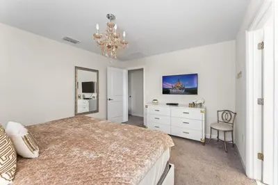 a bedroom with a bed and a desk and a chandelier at Disney Getaway Private Pool Themed Bedrooms. Book Now SLR499 in Kissimmee