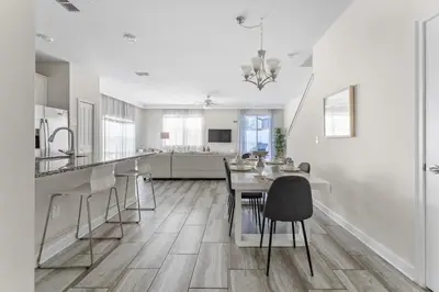 a white kitchen with a table and chairs in it at Disney Getaway Villa with Private Pool Hot Tub. Book Now SLR502 in Kissimmee