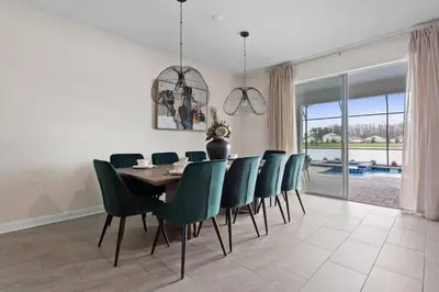 a dining room with a table and green chairs at Disney Private Pool Game Room Themed Bedrooms. Book Now SLR493 in Kissimmee
