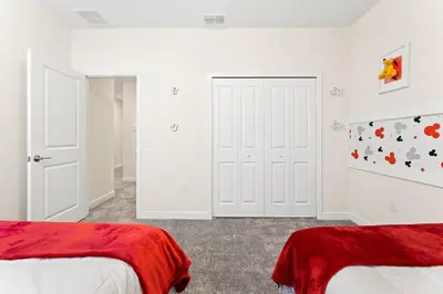 two beds in a bedroom with white walls at Disney Private Pool Hot Tub Themed Bedrooms. Book Now SLR494 in Kissimmee
