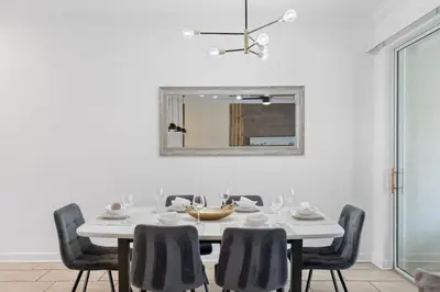 a white dining room with a white table and chairs at Disney Getaway Private Pool Themed Bedrooms. Book Now SLR370 in Kissimmee