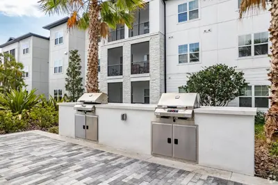 a couple of barbecue units in front of a building at Pinnacle Apartments W Amenties by Heavenly Homes in Orlando