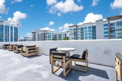 a balcony with chairs and a table and buildings at 3 bedroom Corner Suite in Orlando