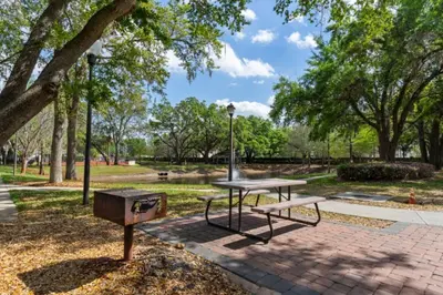 a picnic table and a grill in a park at Cozy Family House near Disney 8108 in Kissimmee