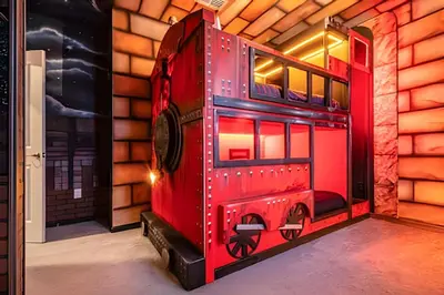 a red toy train on display in a room at 6Q Cinema, Game Room e Spa Privado - 18 hóspedes in Orlando