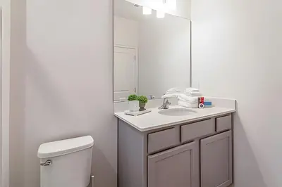 a bathroom with a toilet and a sink and a mirror at 6Q Cinema, Game Room e Spa Privado - 18 hóspedes in Orlando