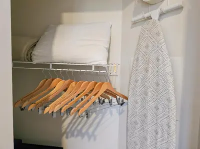 a closet with a rack of shirts and a pillow at 2BR 2BA Grand Duo Suite Sleeps 8 Near Universal and I Drive in Orlando