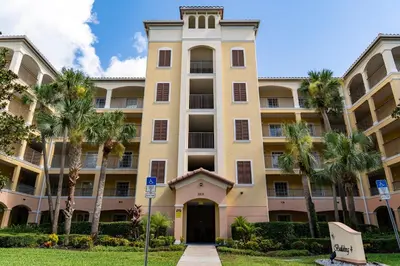 an apartment building with palm trees in front of it at WorldQuest Orlando Resort in Orlando