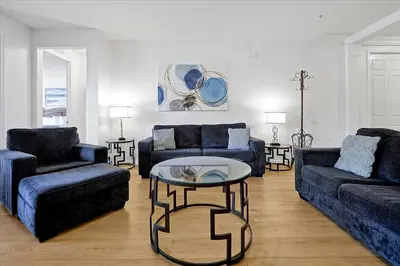 a living room with two blue couches and a table at Epic Universe Beautiful Modern Condo-Vista Cay-2026 in Orlando