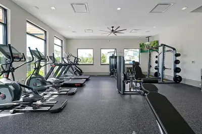a gym with several treadmills and cardio machines at Epic Paradiso Mansion-Pool,Game Room,Theater-4 in Orlando