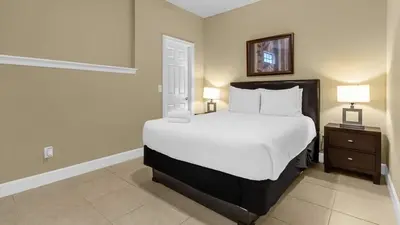 a bedroom with a large white bed and two lamps at Sunny Summer Magic - Stay in TownHome by Disney in Orlando