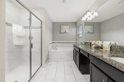 a bathroom with a shower and a sink and a tub at Luxe Lakeview Private Pool SPA 10 Min Disney in Kissimmee
