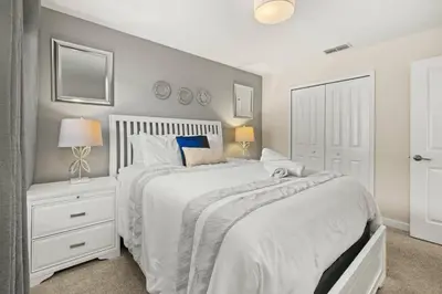 a bedroom with a white bed and a white nightstand at Luxe Lakeview Private Pool SPA 10 Min Disney in Kissimmee