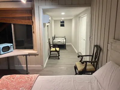 a room with two chairs and a bed and a hallway at Light and Easy Getaways in Orlando