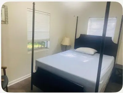 a bedroom with a bed with a four poster bed sidx sidx sidx sidx at Light and Easy Getaways in Orlando