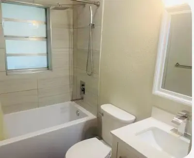 a bathroom with a toilet and a tub and a sink at Light and Easy Getaways in Orlando