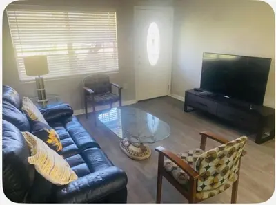 a living room with a leather couch and a glass table at Light and Easy Getaways in Orlando