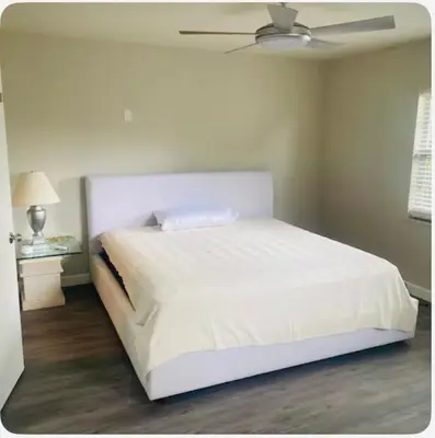 a white bed in a bedroom with a ceiling at Light and Easy Getaways in Orlando