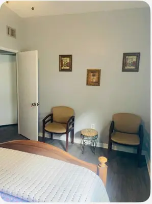 a bedroom with two chairs and a bed and a table at Light and Easy Getaways in Orlando