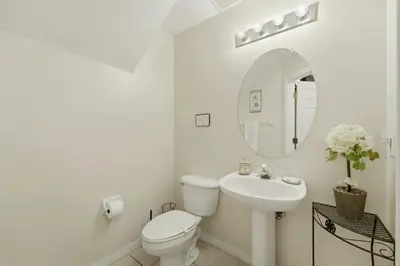 a white bathroom with a toilet and a sink at Near Disney Pool Hot Tub Stunning Water View in Kissimmee