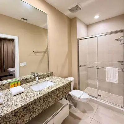 a bathroom with a toilet and a sink and a shower at Spacious 4-Suite Villa with Balcony, Magic Village in Orlando