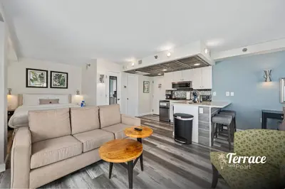 a living room and kitchen with a couch and a bed at Skyline Studio Condo with Private Terrace and Epic Universe View in Orlando