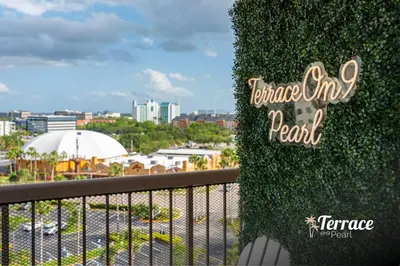 a ivy covered balcony with a view of a city at Skyline Studio Condo with Private Terrace and Epic Universe View in Orlando
