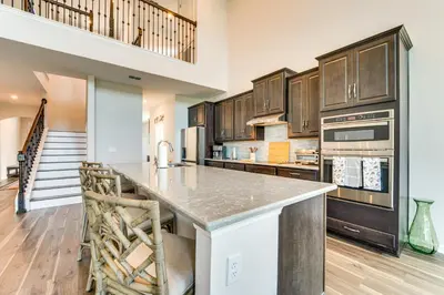 a kitchen with wooden cabinets and a large island at Pool Access Family Gem with Views in St Cloud! in Saint Cloud