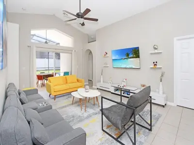 a living room with a couch and a table at Castle Keys Salt Water Pool Home 10 mins to Disney in Kissimmee
