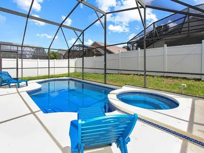 a swimming pool with two blue chairs and a swimming poolvisor at Castle Keys Salt Water Pool Home 10 mins to Disney in Kissimmee