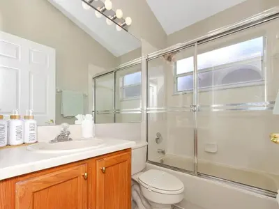 a bathroom with a shower and a toilet and a sink at Castle Keys Salt Water Pool Home 10 mins to Disney in Kissimmee