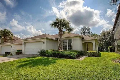a house with a palm tree in a yard at Poolside Vacation Home in Kissimmee Near Disney in Kissimmee
