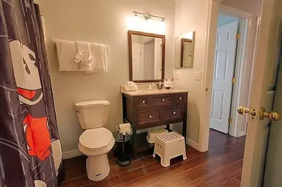 a bathroom with a toilet and a sink and a mirror at Poolside Vacation Home in Kissimmee Near Disney in Kissimmee