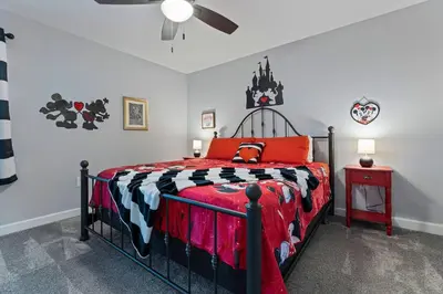 a bedroom with a bed with a black and red comforter at NEW 9Bdrm S. Facing Pool on Preserve near Dis/Univ in Kissimmee
