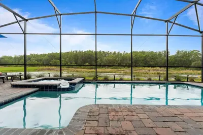 an indoor swimming pool with a large glass building at NEW 9Bdrm S. Facing Pool on Preserve near Dis/Univ in Kissimmee