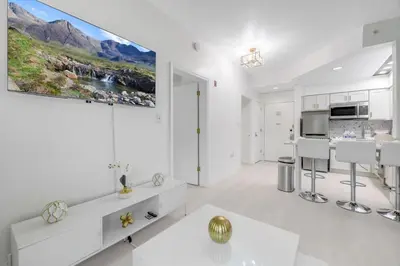 a white living room with a large painting on the wall at Luxury Private Apt at Disney Area in Orlando