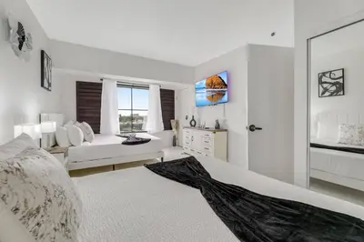 a large white bedroom with a bed and a window at Luxury Private Apt at Disney Area in Orlando