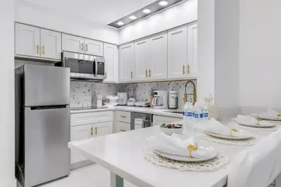 a white kitchen with white appliances and white cabinets at Luxury Private Apt at Disney Area in Orlando