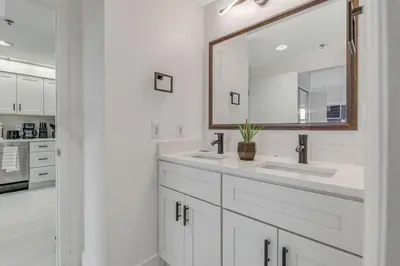a white bathroom with two sinks and a mirror at Luxury Private Apt at Disney Area in Orlando