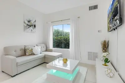 a white living room with a couch and a table at Luxury Private Apt at Disney Area in Orlando