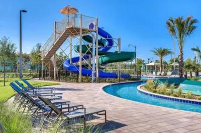 a water slide at a resort with chairs and a pool at Sunset Retreat at Storey Lake Resort by Shine Villas condo in Kissimmee