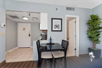 a dining room with a black table and chairs at Delightful Studio Condo with Garden View Balcony 7 Mins to Universal in Orlando
