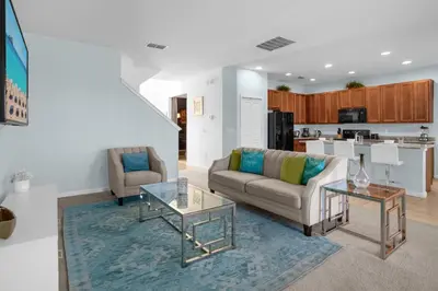 a living room with a couch and a table at Upstay - Resort Home w Cinema Pool & Lake View in Kissimmee